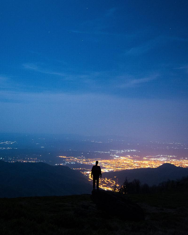 a man on a night hike above the city