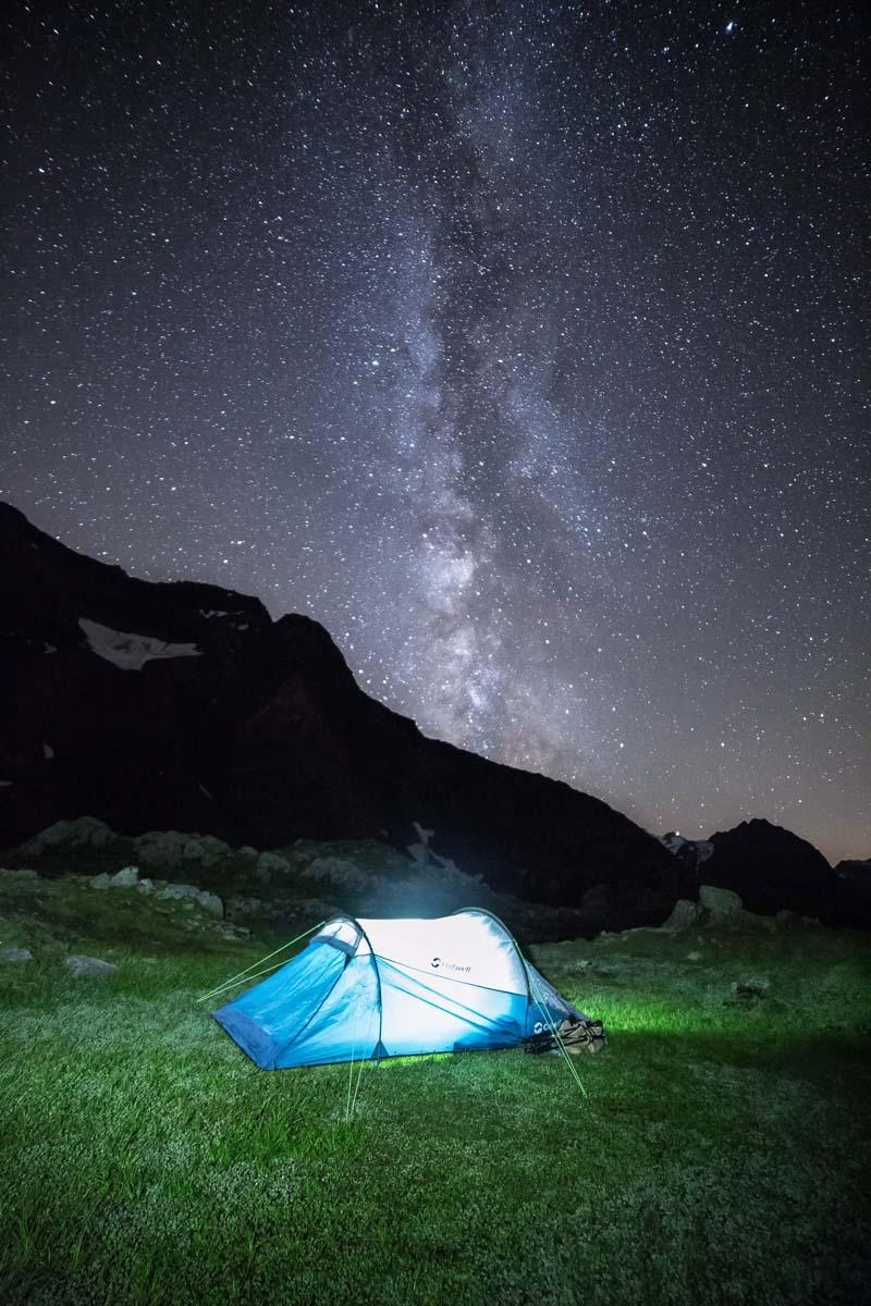a small blue 2 man tunnel tent under the stars