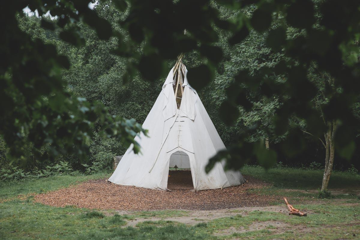 an extra tall tent in the forest