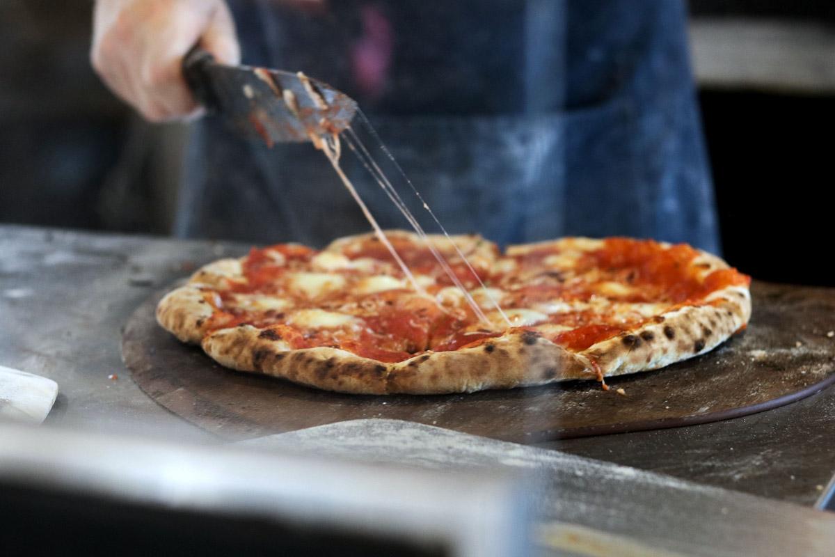 chef cutting a pizza