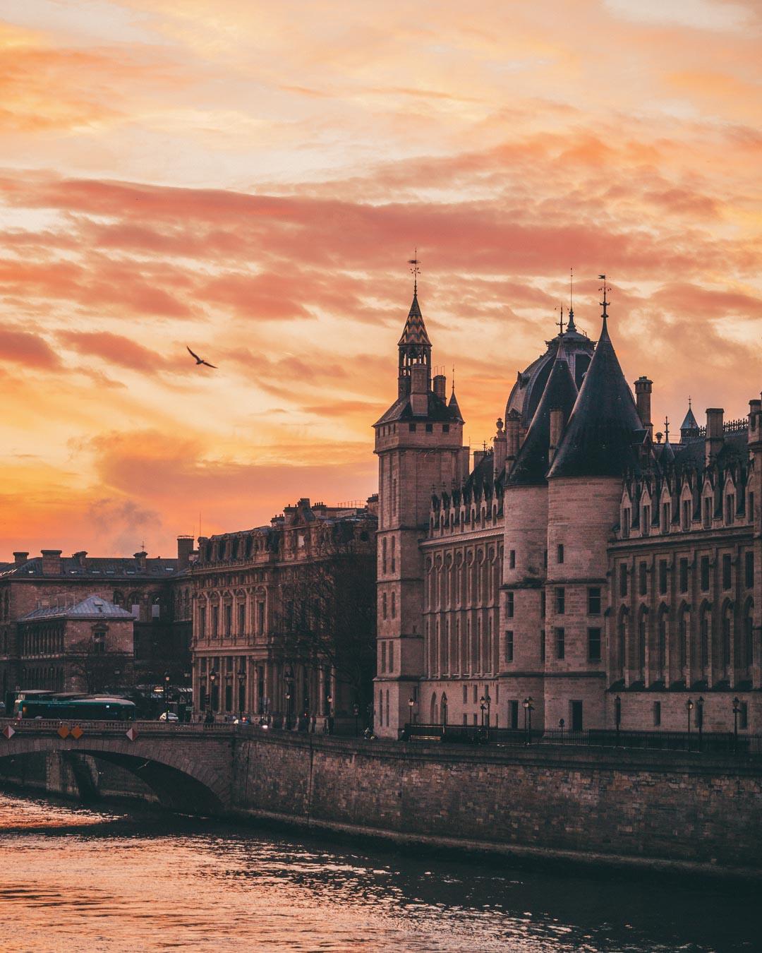 the sun rising over la conciergerie in paris