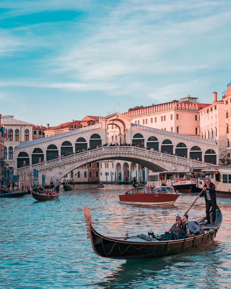 gondolier in front of the rialto bridge