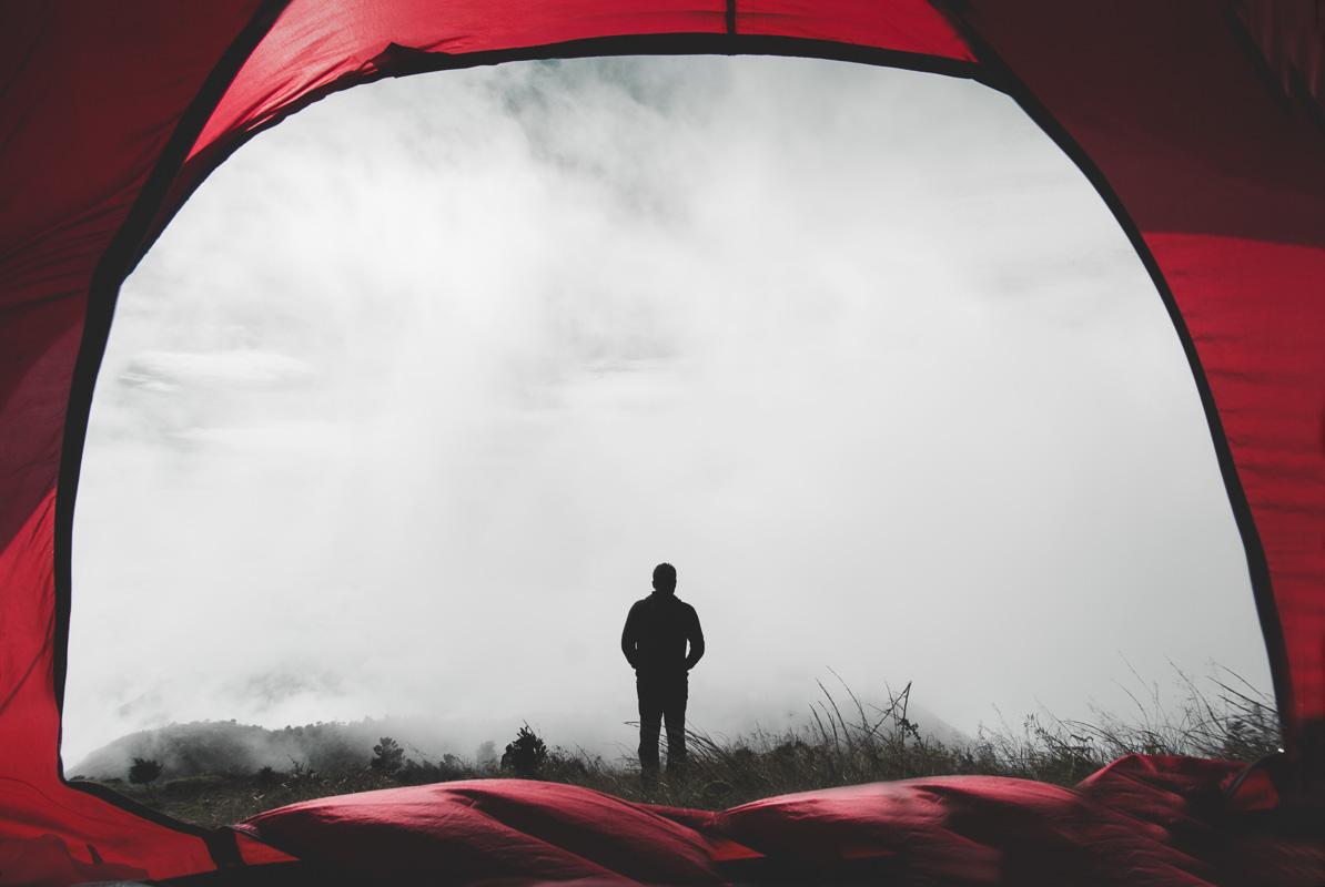 man standing in the mist in front of his 4 man stand up tent