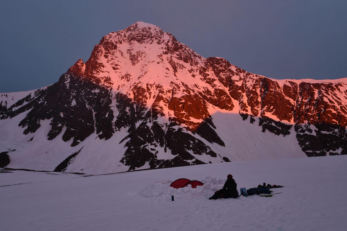 man watching sunrise next to his 4 person 4 season tent