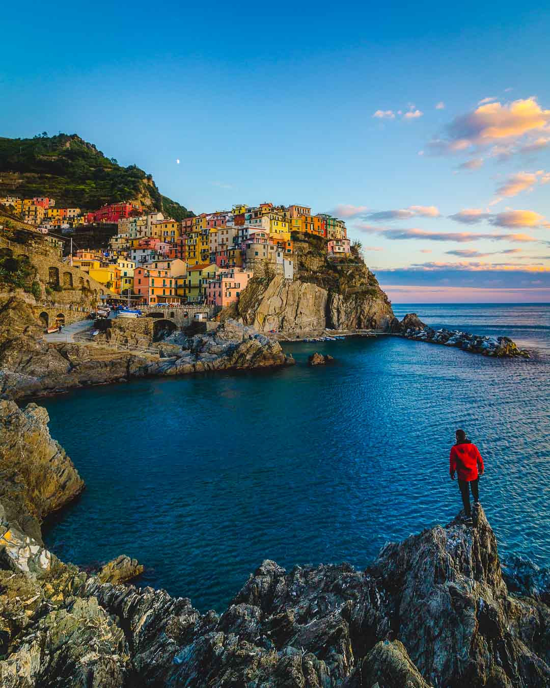 standing on a cliff looking at all the best places to stay in manarola italy