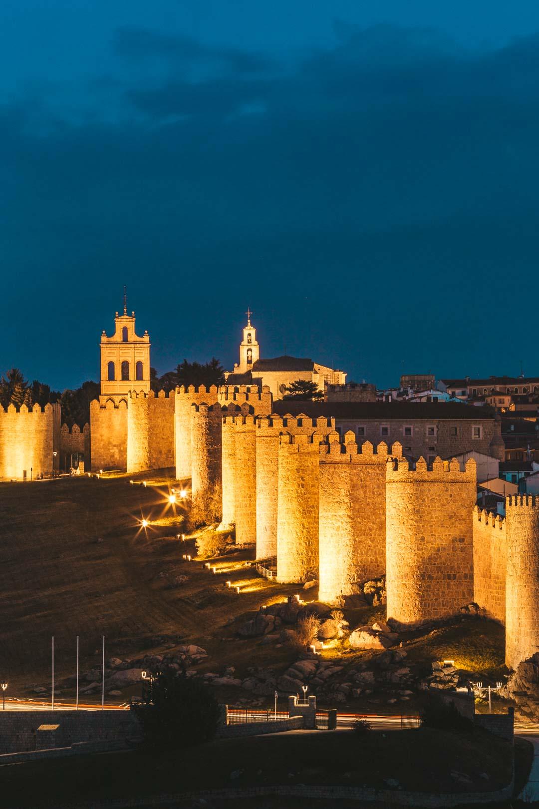walls of avila at night with the steeple of el carmen
