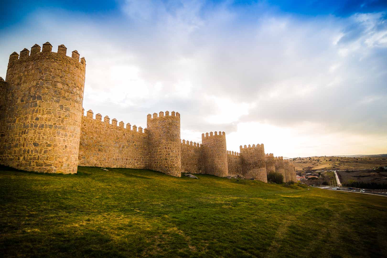 the sun setting over the fortified walls of avila