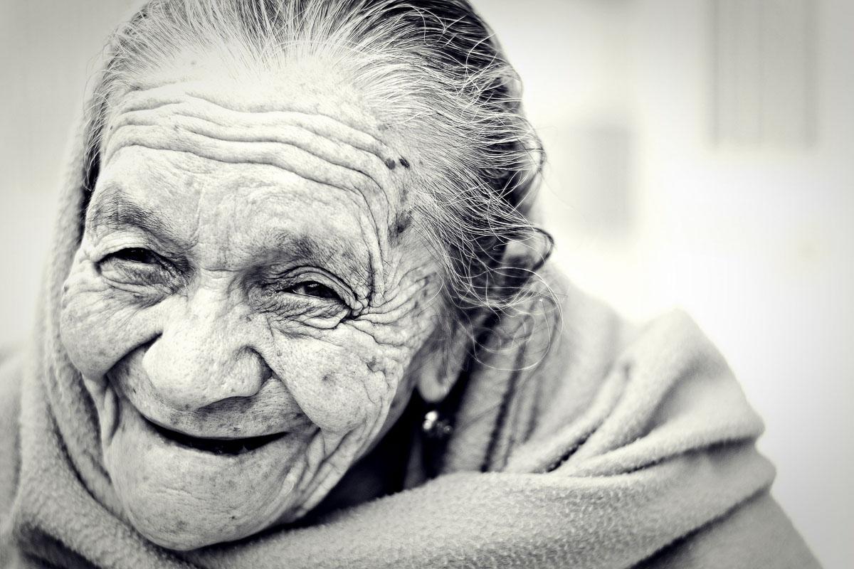 mujer vieja sonriendo después de leer citas divertidas sobre la sonrisa