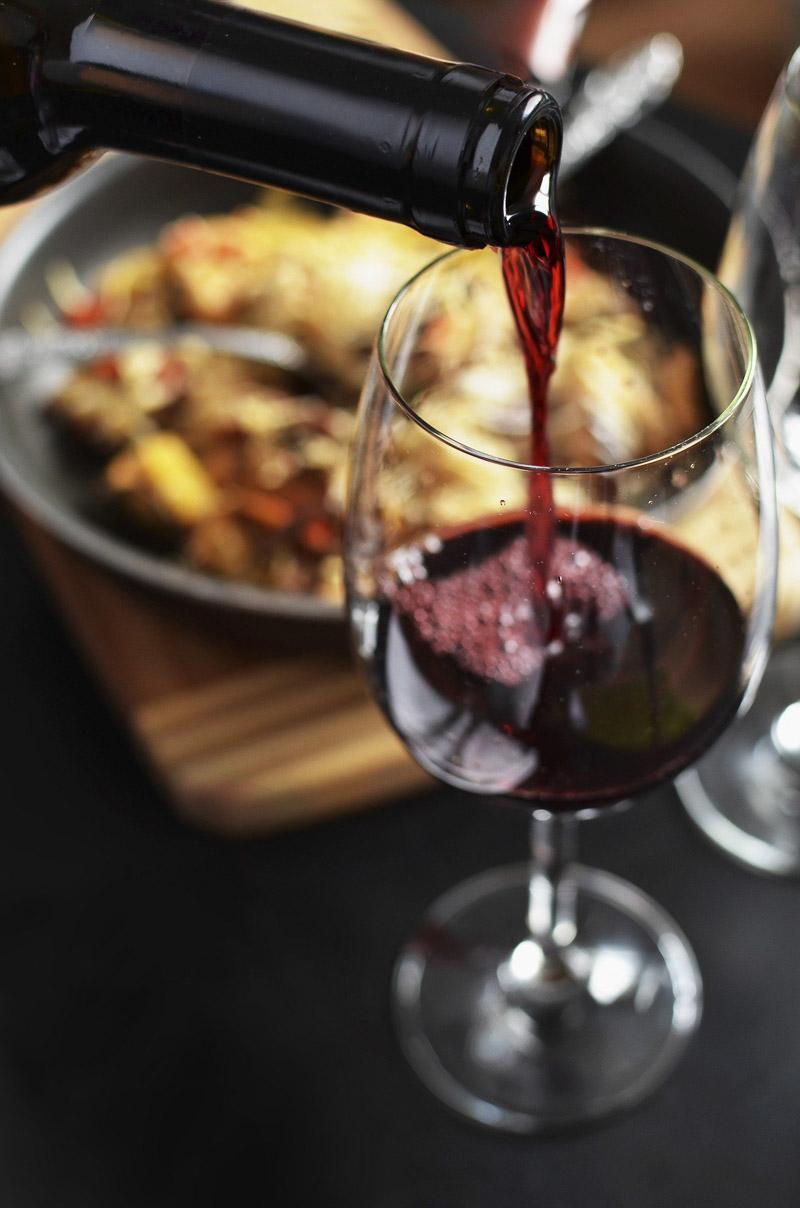 pouring a glass of red wine in italy