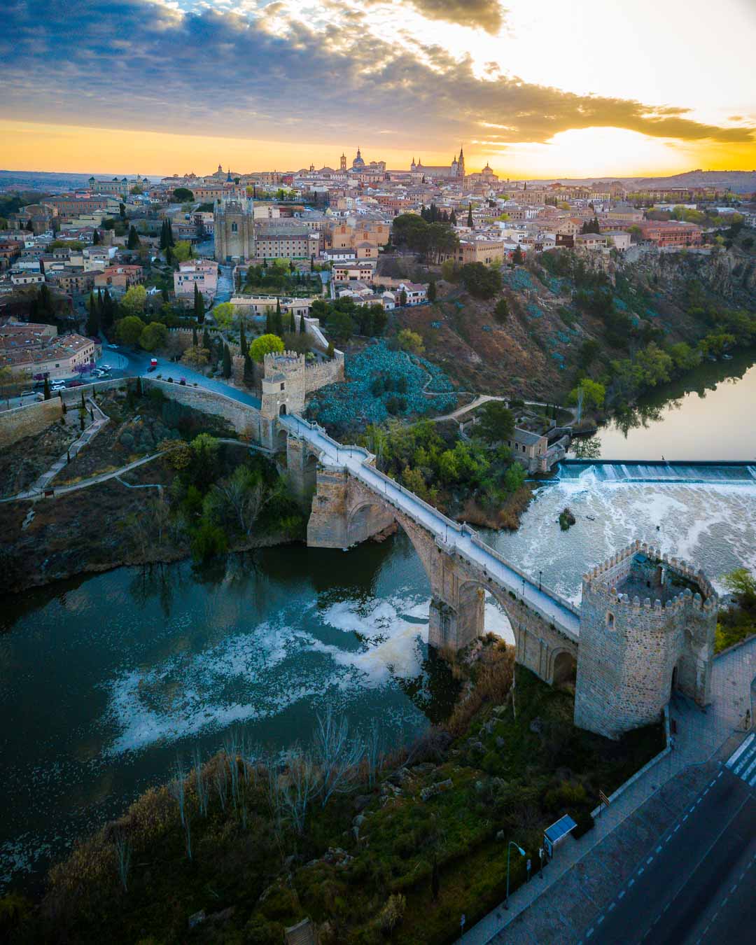 sunrise over the puente san martin and the old town as seen from the sky