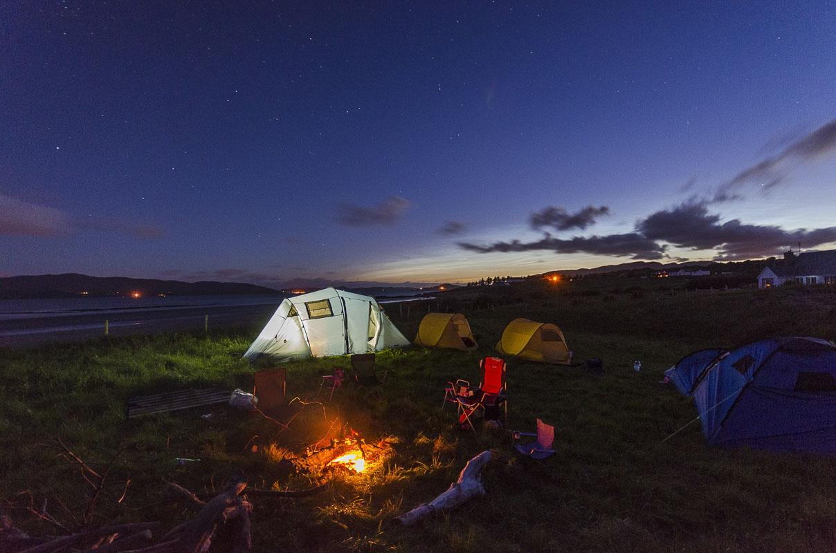 tents around a campfire with a white 4 person tunnel tent