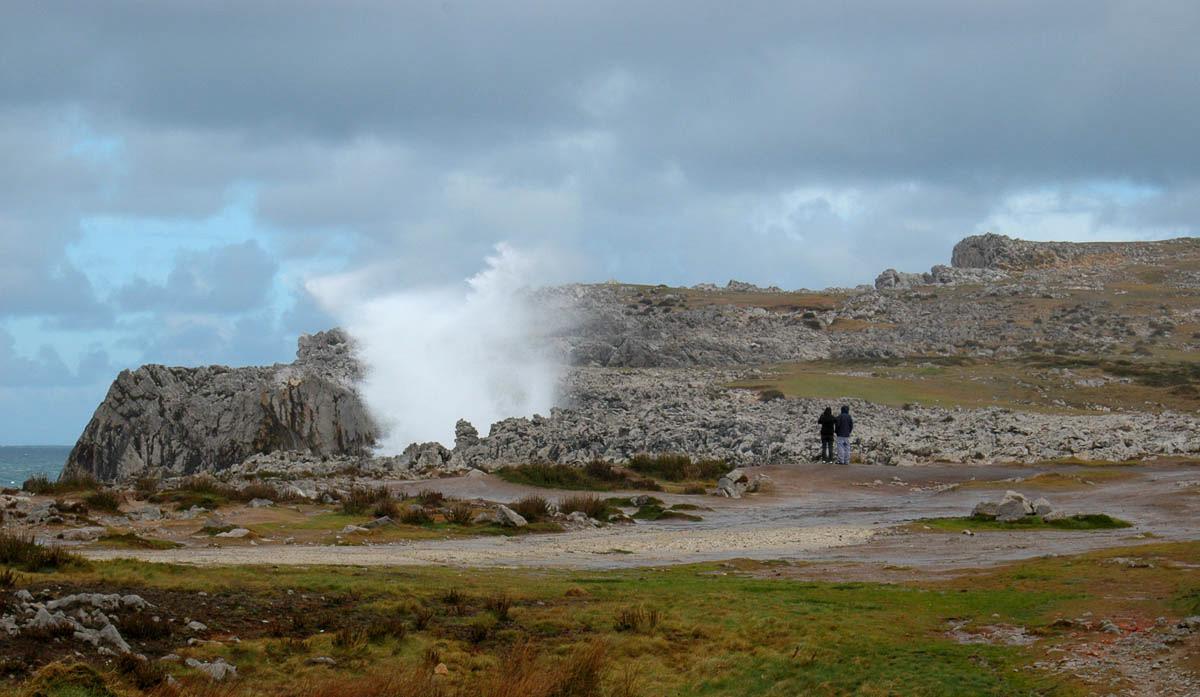 couple watching a geyser in pria asturias
