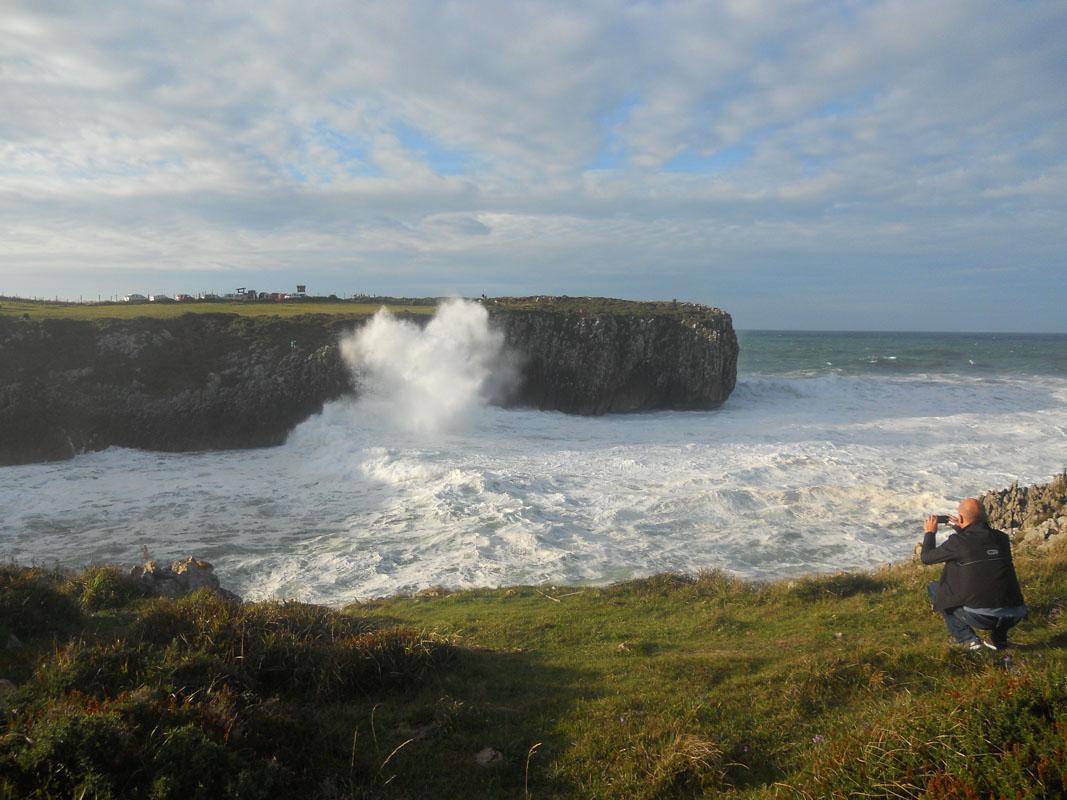 man taking a photo of the geyser in bufones de pria