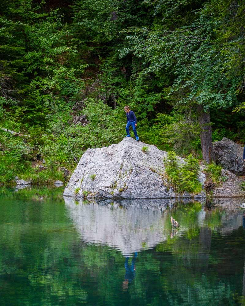 kid standing on rock in lac vert