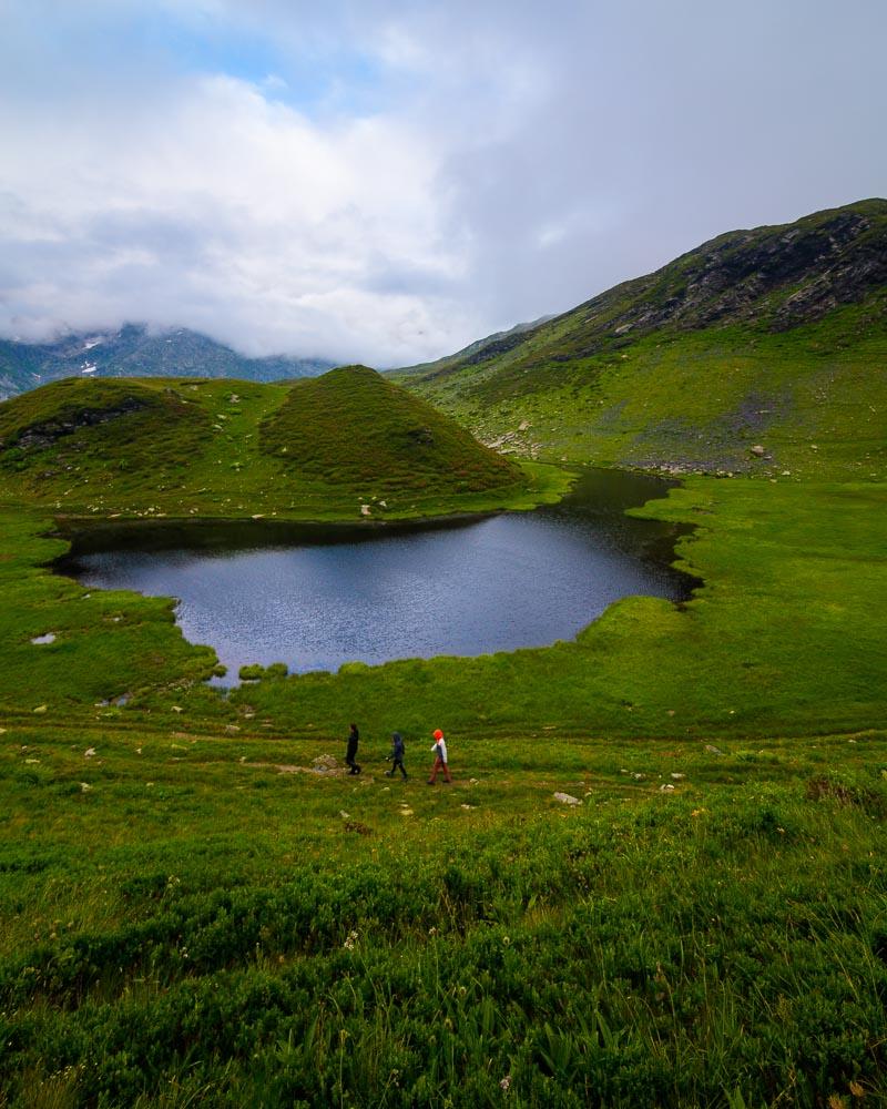 hikers in front of small lake in passy