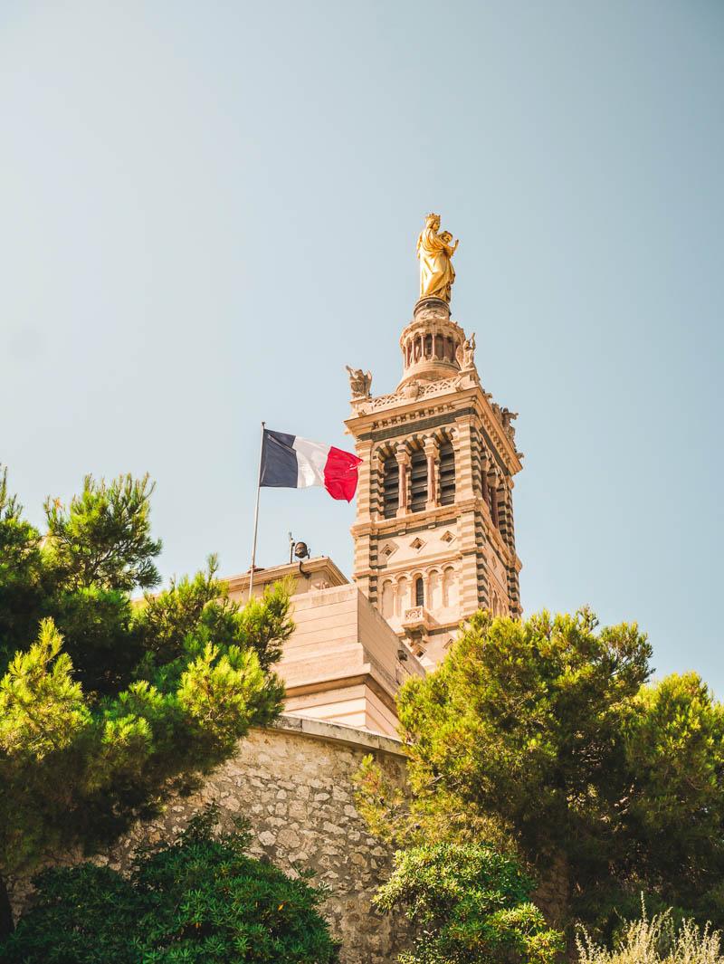 notre dame de la garde church tower with the flag of france