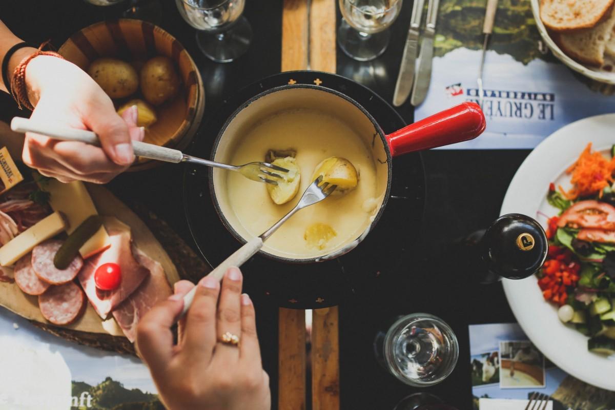 eating cheese fondue in gruyere in one of the best day trips from geneva in winter