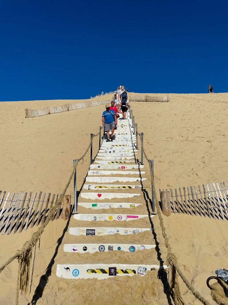 climbing the stairs to the pilat sand dune